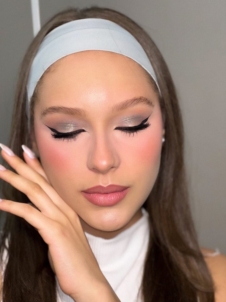 Maquiagem com delineado gráfico prateado e blush marcante