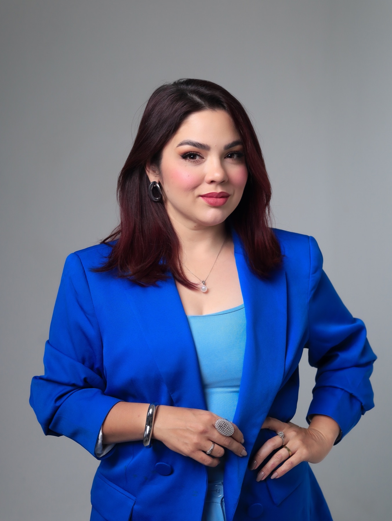 Suzzane Rodrigues sorrindo, em pose profissional com os dois braços à mostra